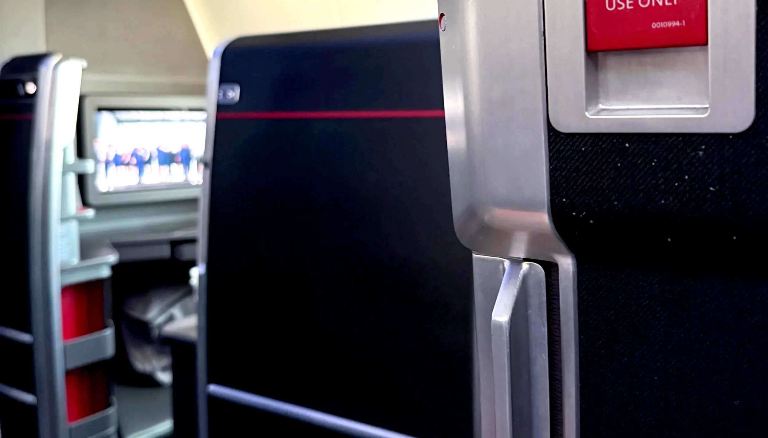 Close-up of a business-class airplane seatback and video screen