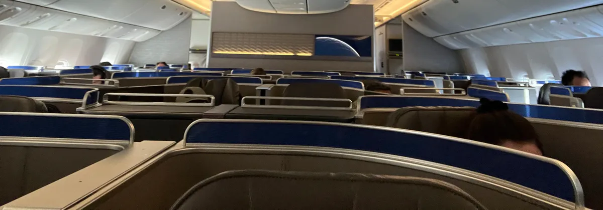 Airplane cabin with rows of enclosed blue and beige seats