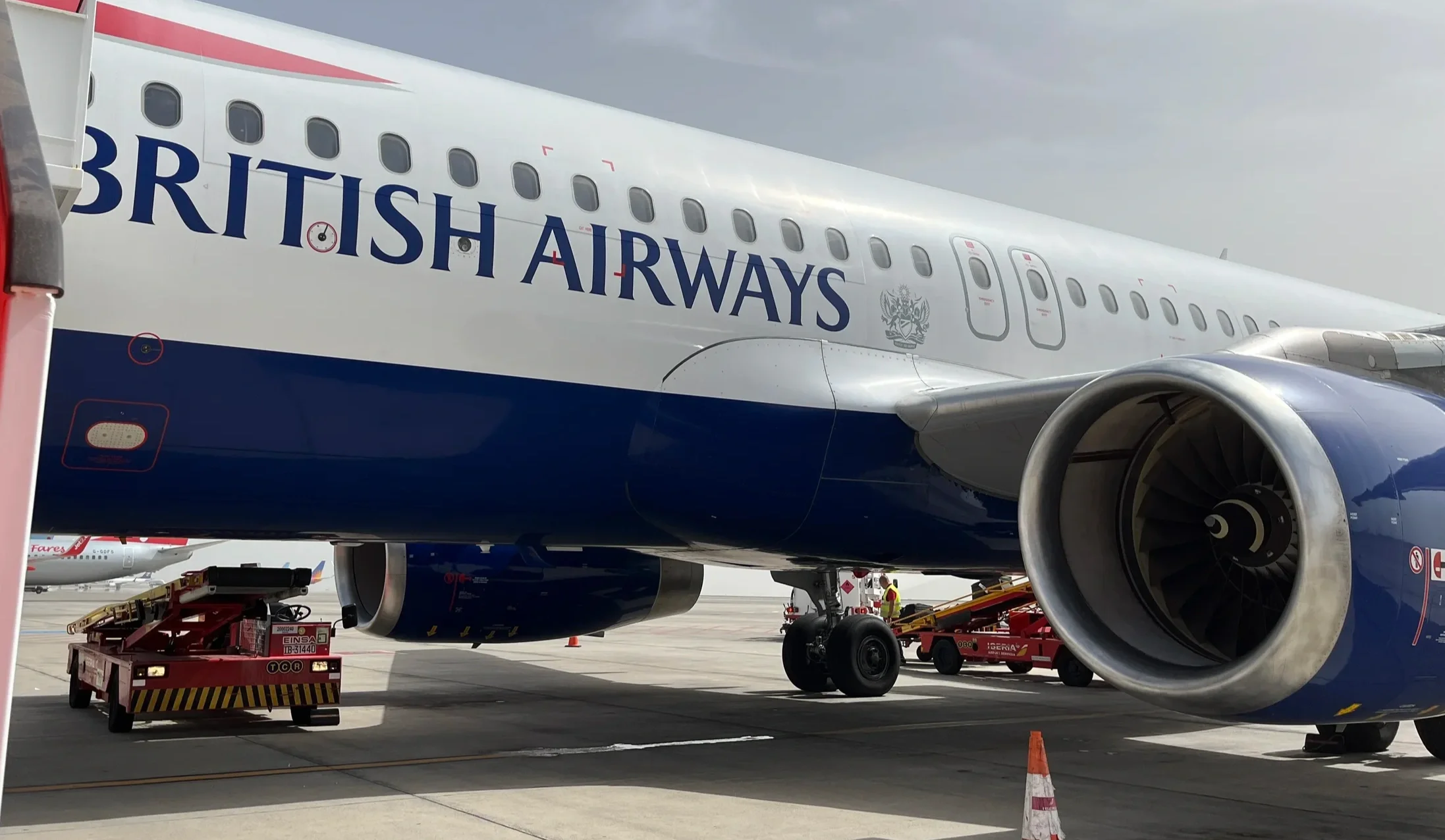 British Airways fuselage and engine beside ground equipment
