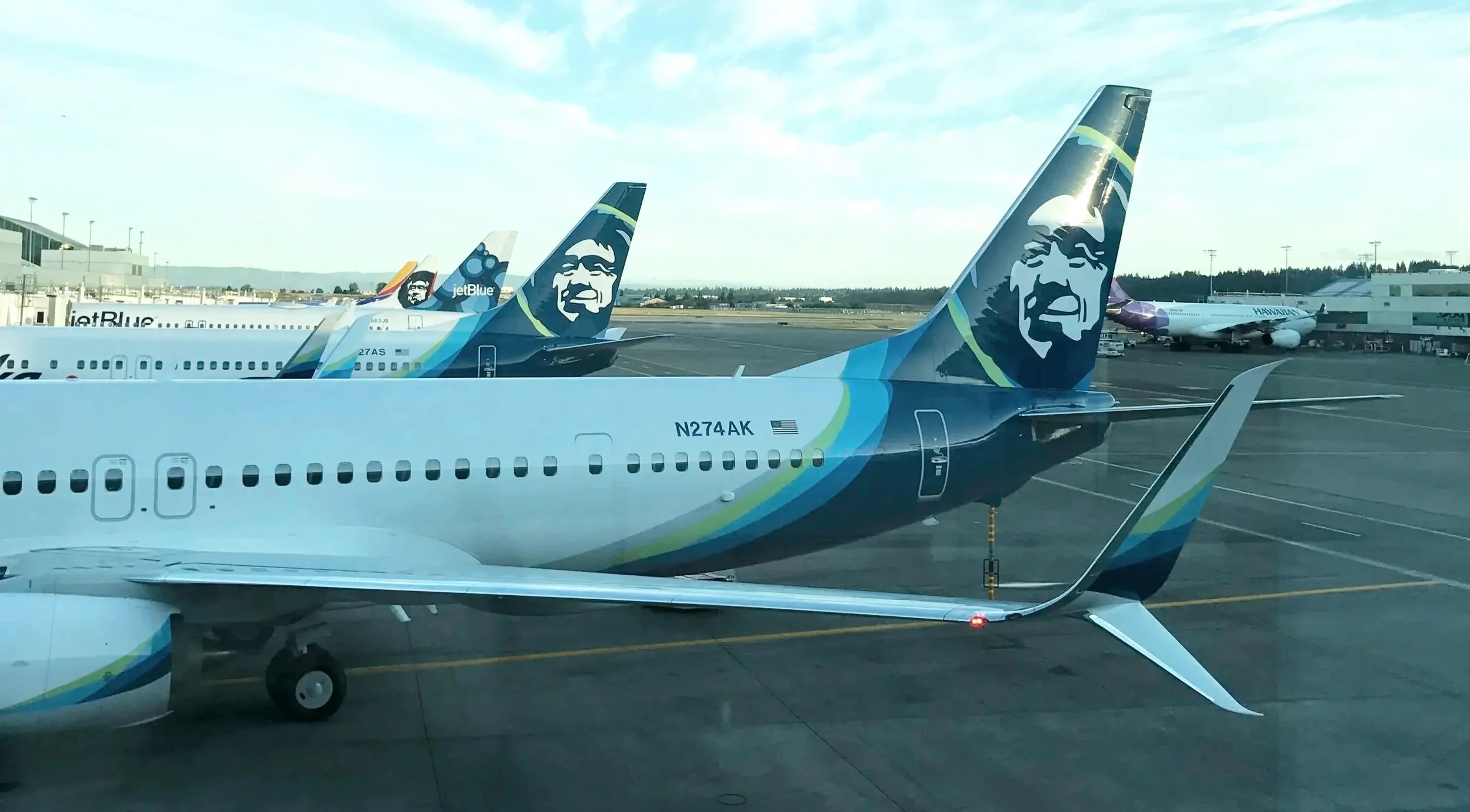 Alaska Airlines jets on the tarmac with a jetBlue plane nearby